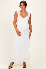 woman wearing a white lace maternity maxi dress with ruffled straps and showing her baby bump