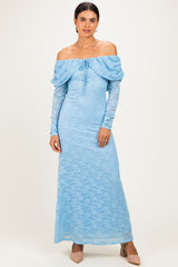 woman wearing a sky blue off-the-shoulder lace maxi dress with long sleeves and a tie detail at the neckline