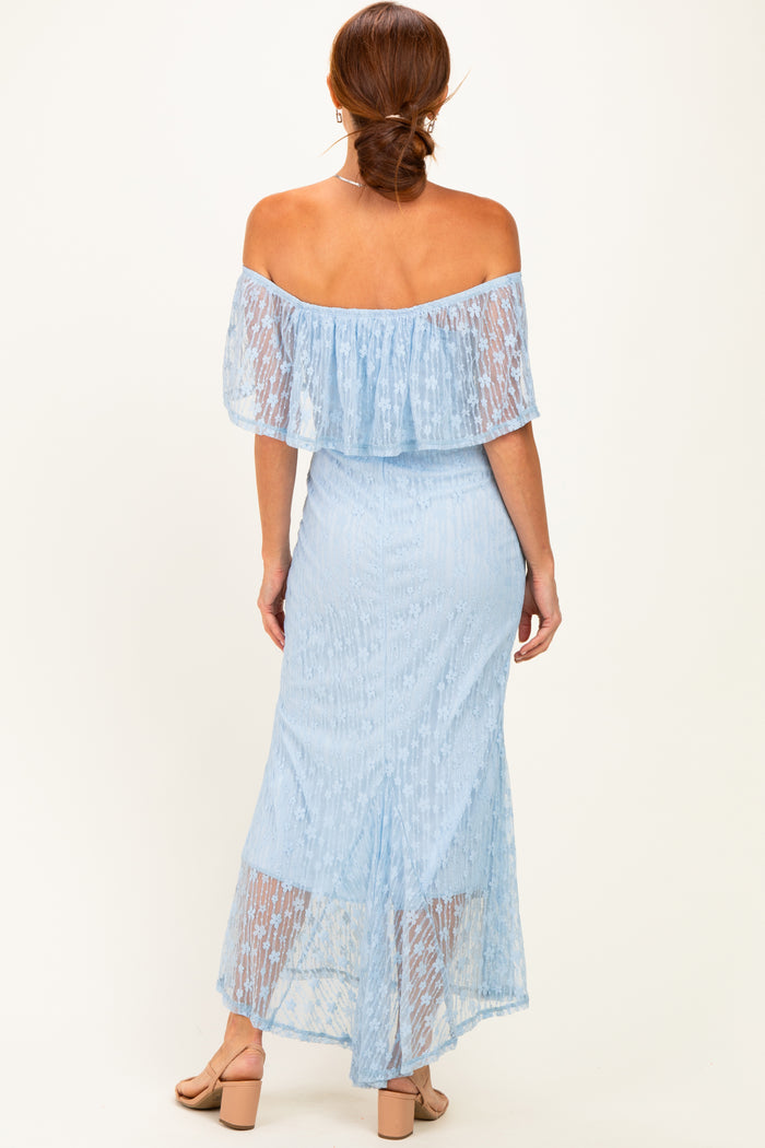 woman wearing a light blue off-shoulder maxi dress with ruffle details and a sheer overlay, viewed from the back