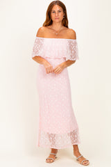 woman wearing a light pink off-the-shoulder maxi dress with lace overlay and a fitted silhouette