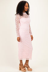 woman wearing a pink long sleeve lace dress with star patterns and a fitted style, paired with beige block-heeled sandals