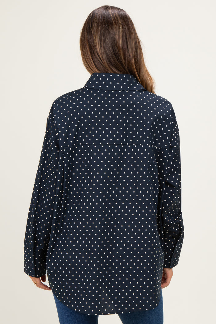 woman wearing a black and white polka dot maternity shirt with a relaxed fit, showing the back view