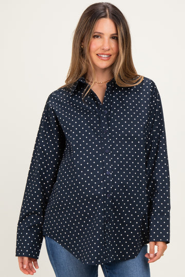 woman wearing a navy maternity button-up shirt with white polka dots and a visible baby bump