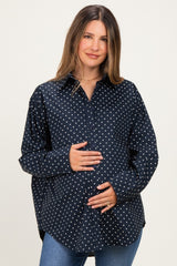 woman wearing a navy blue polka dot maternity shirt and holding her baby bump