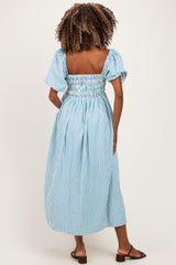 woman wearing a blue and white striped maternity dress with short puff sleeves and a smocked back