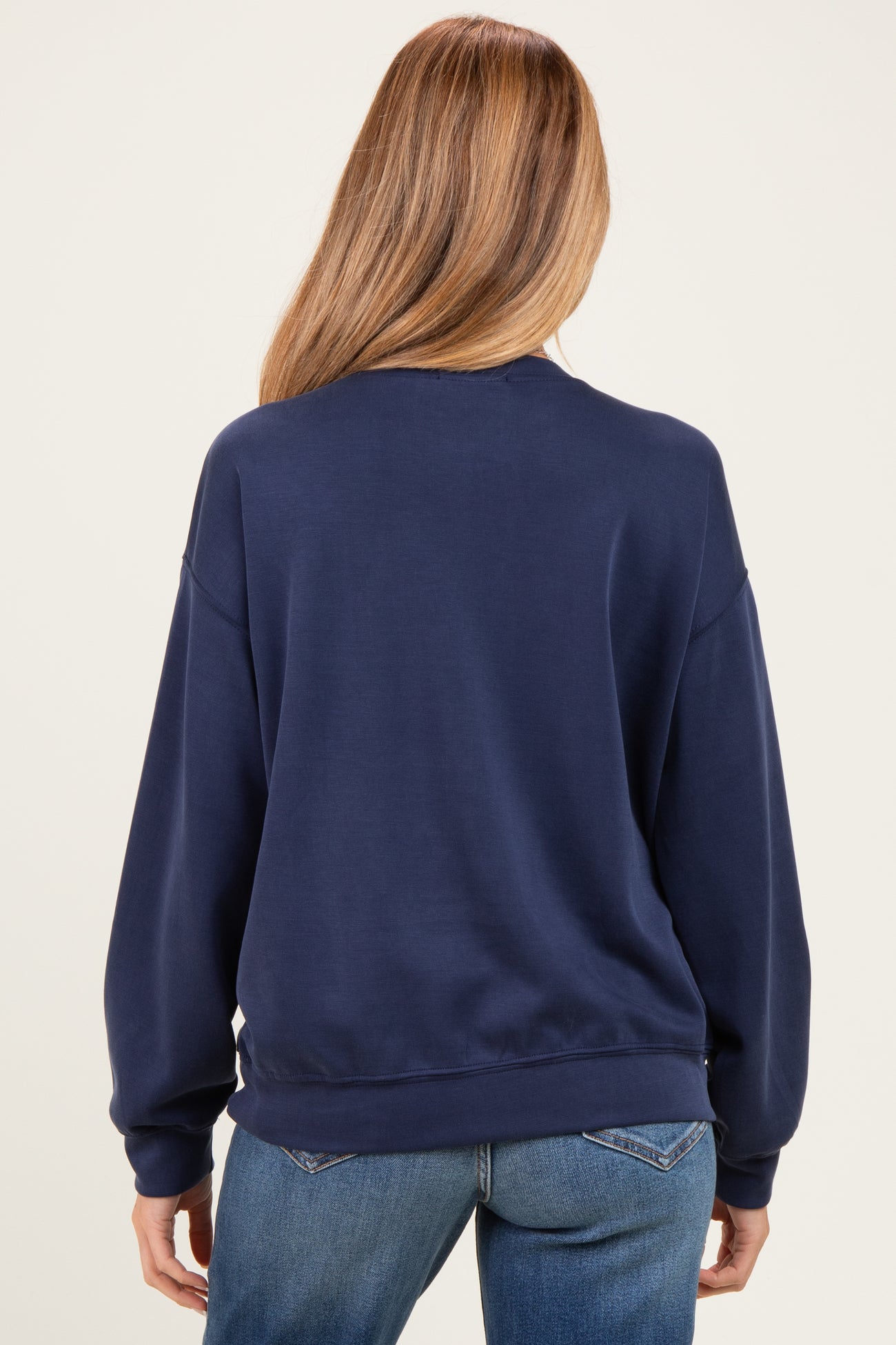 woman wearing a navy blue maternity sweatshirt with a relaxed fit, viewed from the back