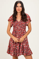 woman wearing a red floral short sleeve dress with a smocked bodice and tiered skirt