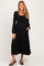 woman wearing a black long sleeve maternity dress with a smocked bodice and pockets, showcasing her baby bump