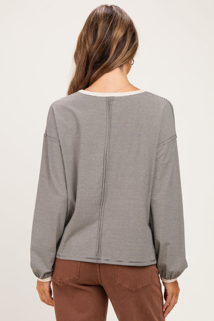woman wearing a gray striped long sleeve maternity top, showing the back view with gathered sleeves