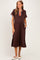 woman wearing a brown maternity polo dress with a striped collar and side slits, showcasing her baby bump