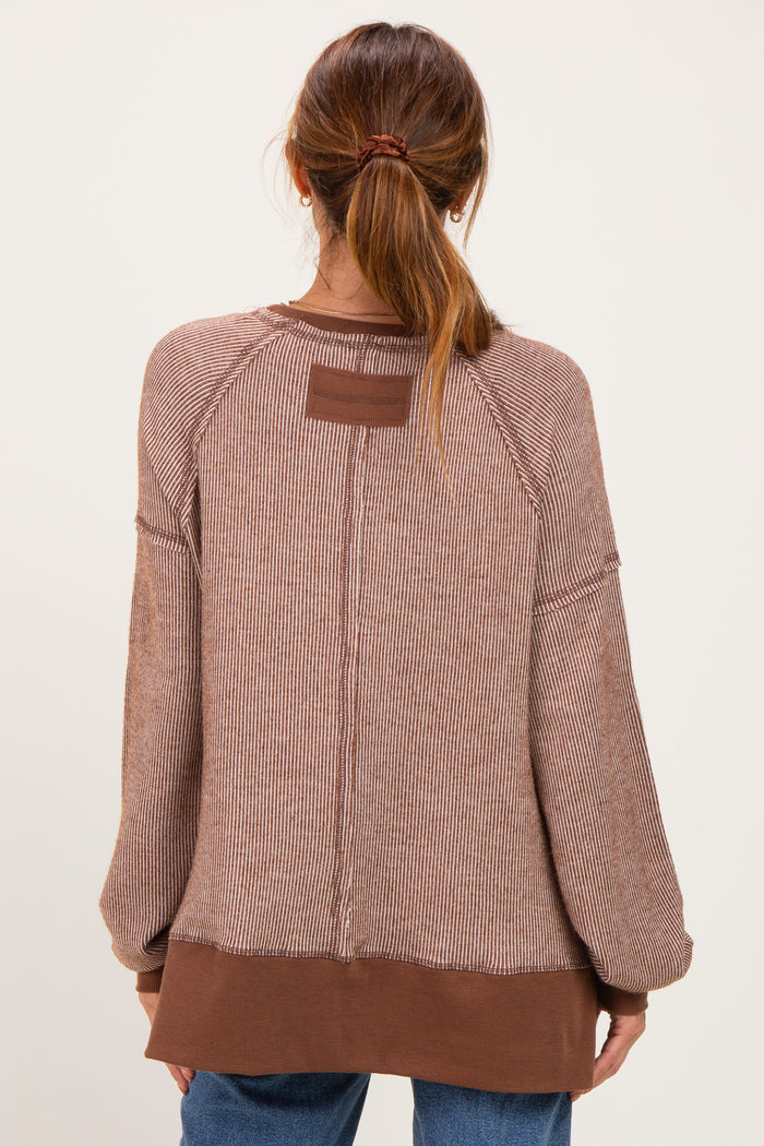 woman wearing a brown striped oversized sweater with raglan sleeves and a contrasting hem, shown from the back