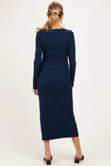 woman wearing a navy blue long sleeve maternity dress, showing a fitted style and ankle length