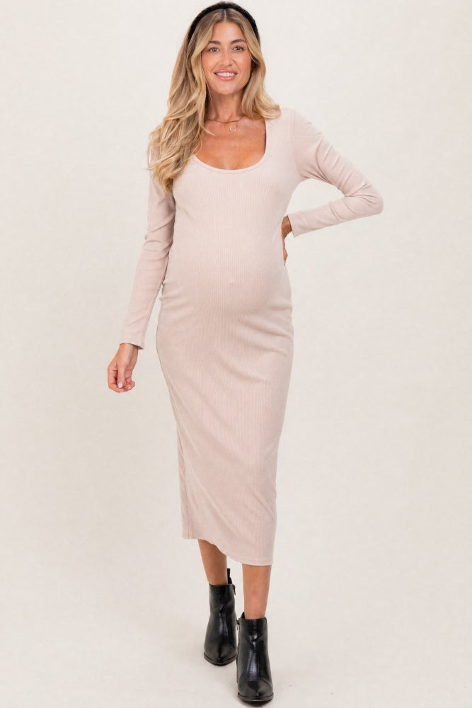 woman wearing a beige long sleeve maternity dress with a scoop neckline and a visible baby bump