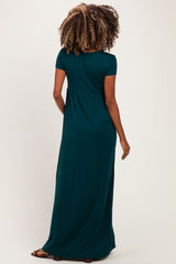 woman wearing a dark green maternity maxi dress with short sleeves and a relaxed fit, showcasing her baby bump