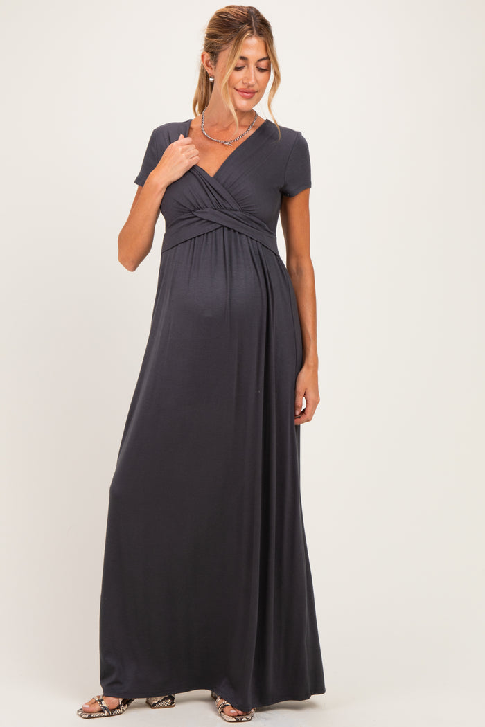 woman wearing a dark gray short sleeve maternity maxi dress with a crossover bodice and baby bump visible