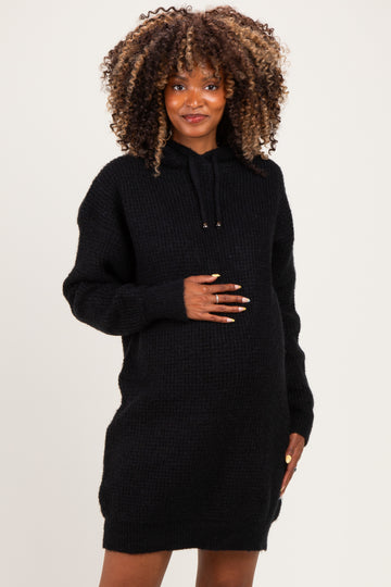 woman wearing a black maternity hoodie dress and holding her baby bump