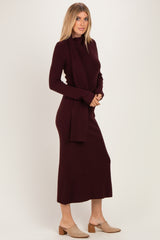 woman wearing a burgundy long sleeve ribbed midi dress with a matching scarf and brown heeled mules