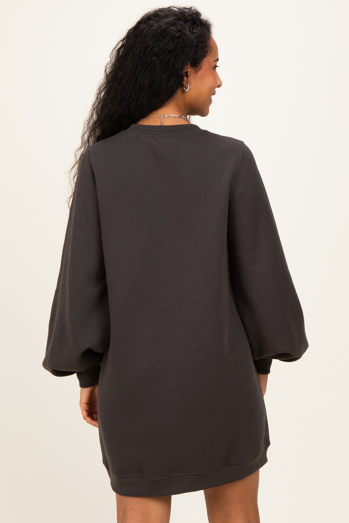 woman wearing a dark gray maternity sweatshirt dress with balloon sleeves, showcasing a relaxed fit from the back