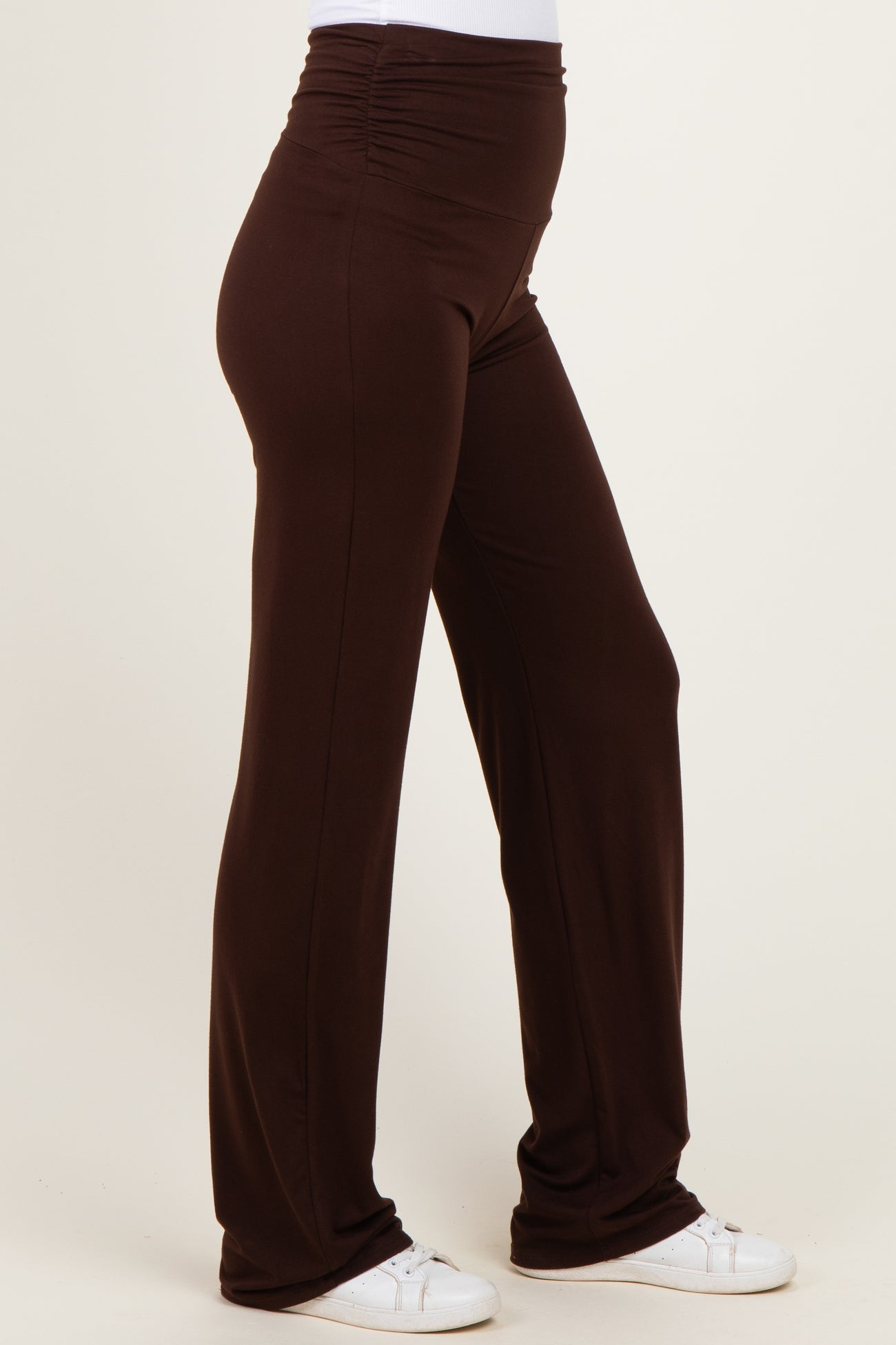 woman wearing brown stretchy pants with a high waistband and gathered side details