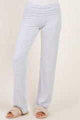 woman wearing light gray wide-leg lounge pants with a fold-over waistband and slip-on fluffy slippers