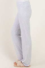 woman wearing light grey lounge pants with a wide waistband and loose fit, paired with cozy slippers