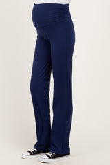 woman wearing navy blue maternity yoga pants with a ruched waistband and a visible baby bump
