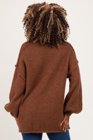 woman wearing a cozy brown oversized maternity sweater, styled with a relaxed fit and soft texture, viewed from the back