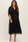 woman wearing a black maternity dress with a flowy silhouette and sequin detailing, showing her baby bump