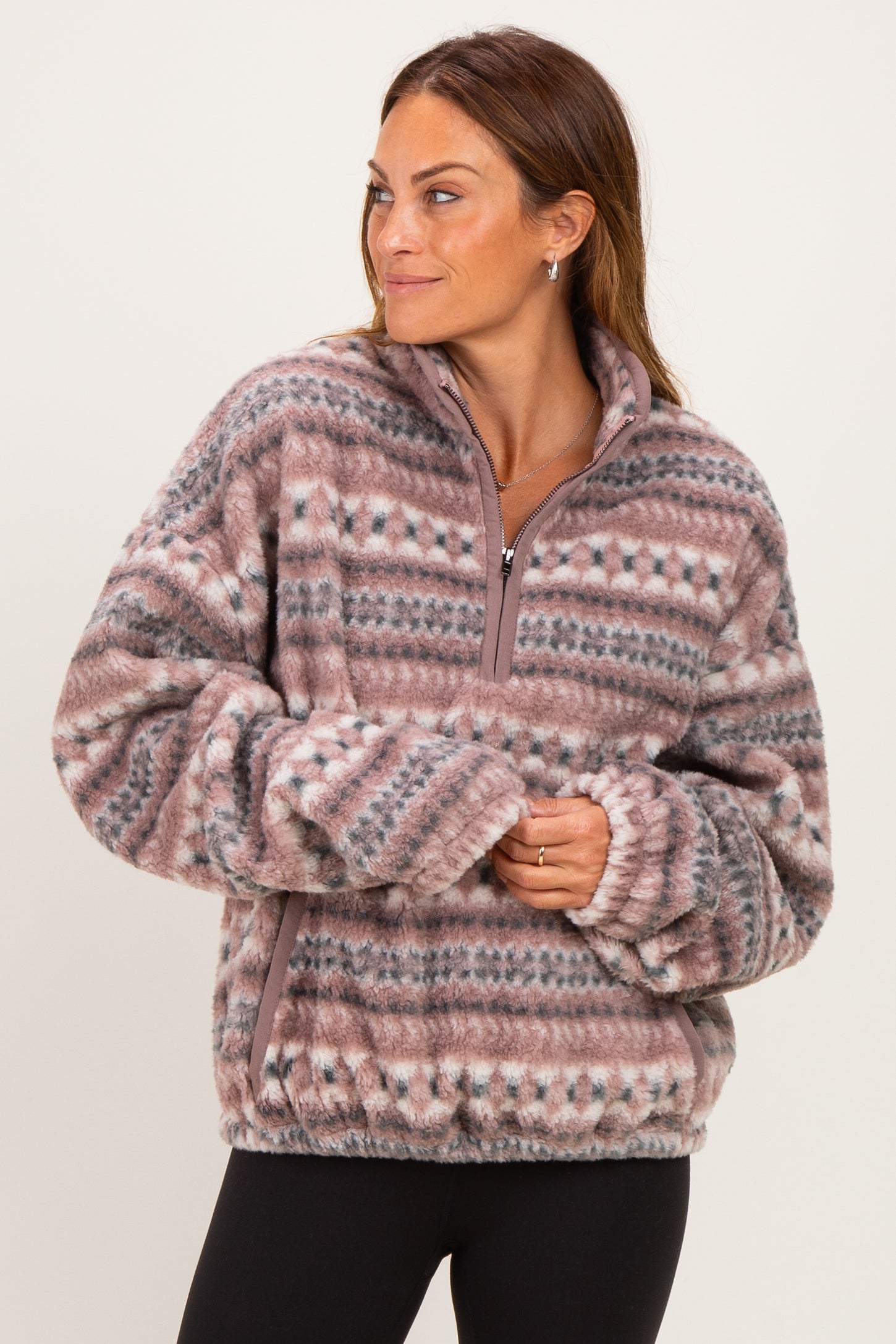 woman wearing a cozy brown and pink patterned fleece pullover with a half zipper and relaxed fit
