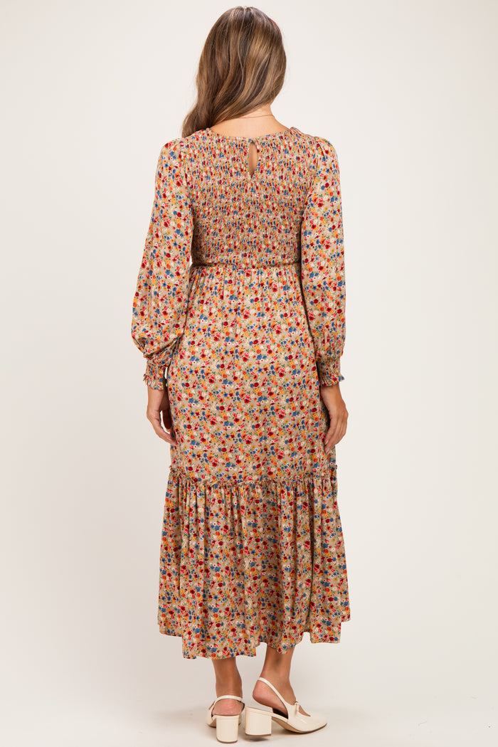 woman wearing a floral long sleeve maternity dress with a smocked bodice and tiered skirt, showing the back view