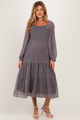woman wearing a patterned long sleeve maternity dress with a tiered skirt and square neckline