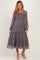 woman wearing a patterned long sleeve maternity dress with a tiered skirt and square neckline