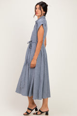 woman wearing a navy blue gingham midi dress with short sleeves and a tie waist detail