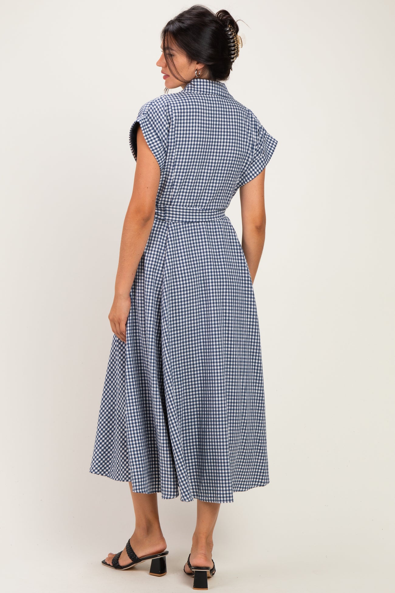 woman wearing a blue and white gingham midi dress with cap sleeves and a tie waist, shown from the back