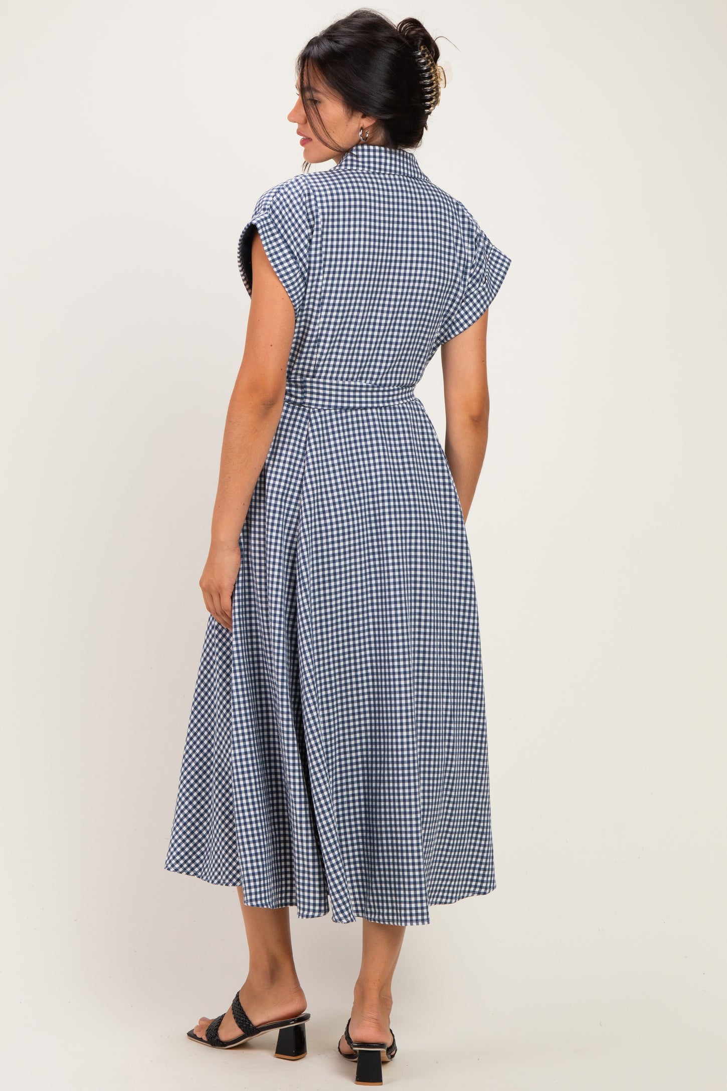 woman wearing a blue and white gingham midi dress with cap sleeves and a tie waist, shown from the back