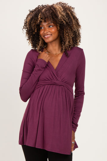 woman wearing a purple maternity top with long sleeves and a wrap design, showing her baby bump