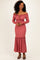 woman wearing a dusty rose off-the-shoulder ribbed maxi dress with ruffled hem and long sleeves