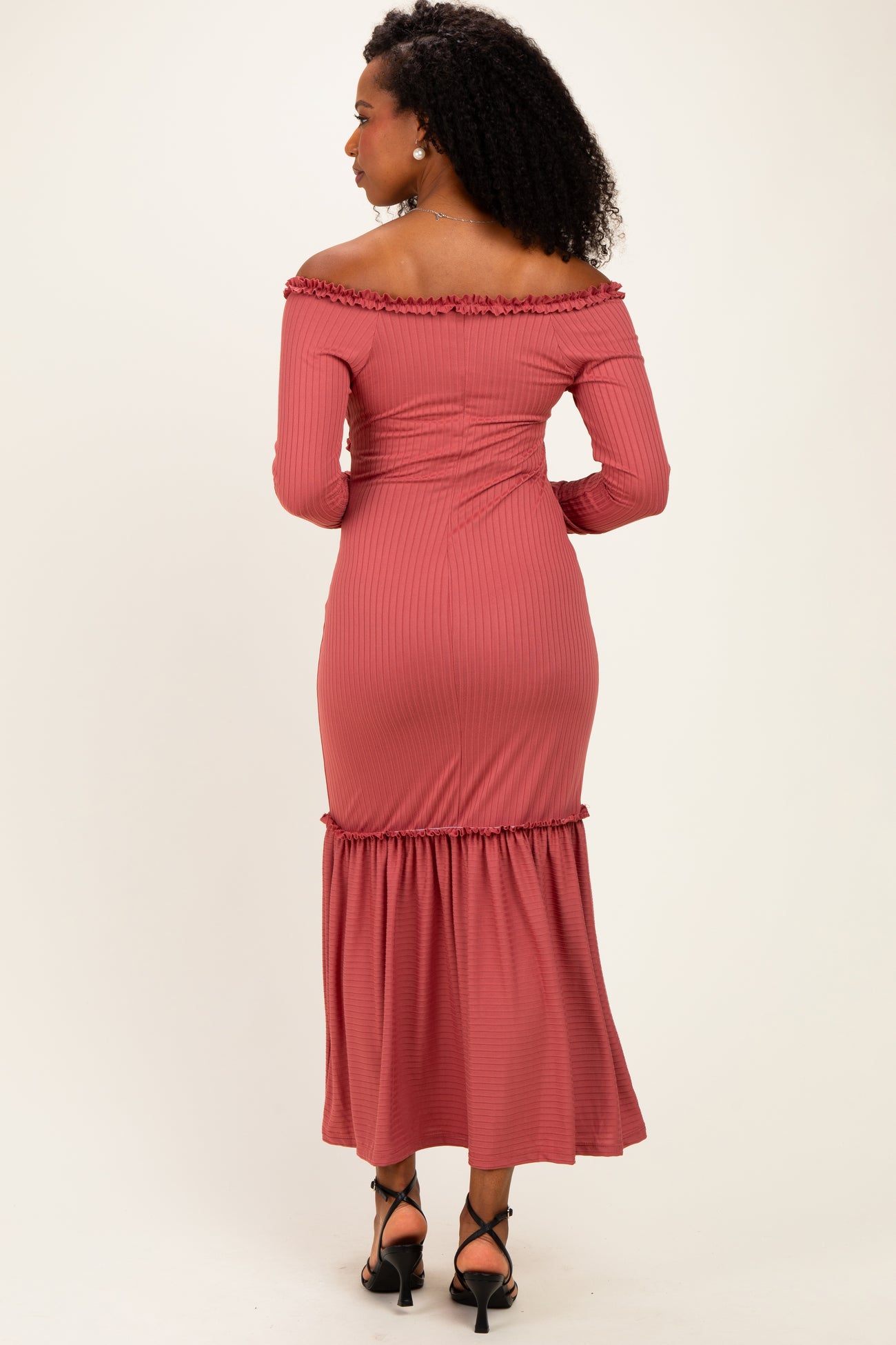 woman wearing a dusty rose off-the-shoulder ribbed maxi dress with a ruffled hem and fitted waist