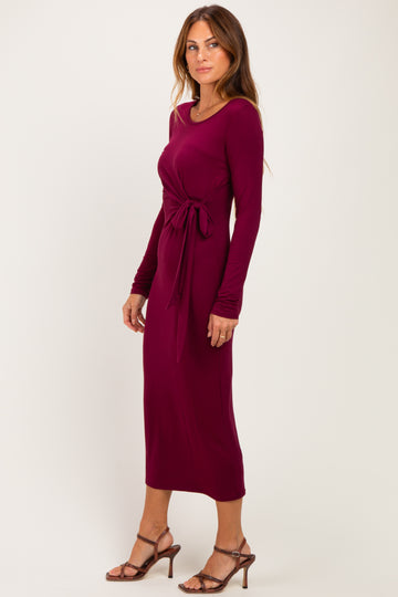 woman wearing a burgundy long sleeve maxi dress with a tie waist detail and strappy heels