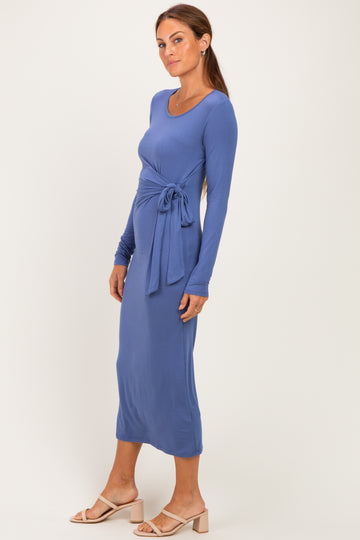 woman wearing a long sleeve blue wrap maxi dress with a tie belt and a fitted silhouette