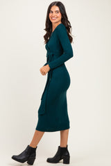 woman wearing a teal long sleeve wrap dress with a tie detail and ankle boots