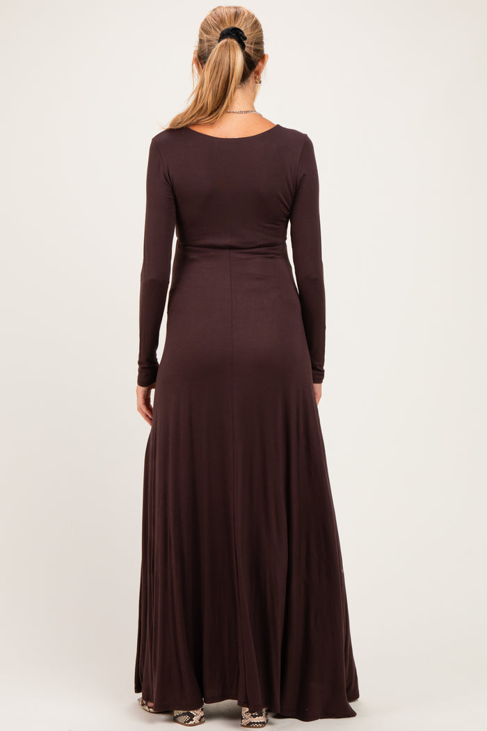 woman wearing a dark brown long sleeve maternity dress with a flowing skirt, showing a smooth back design