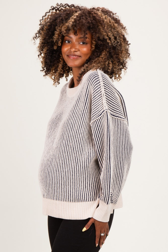 woman wearing a striped maternity sweater with oversized sleeves and a visible baby bump