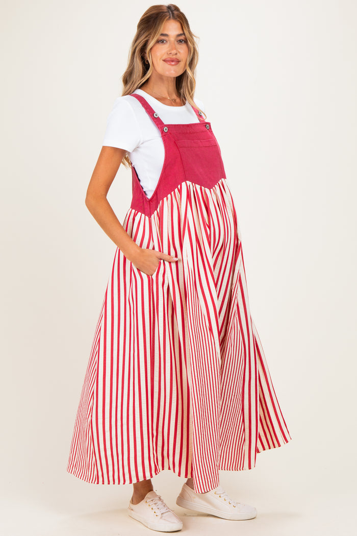 woman wearing a red and white striped maternity dress with pockets over a white top and a visible baby bump