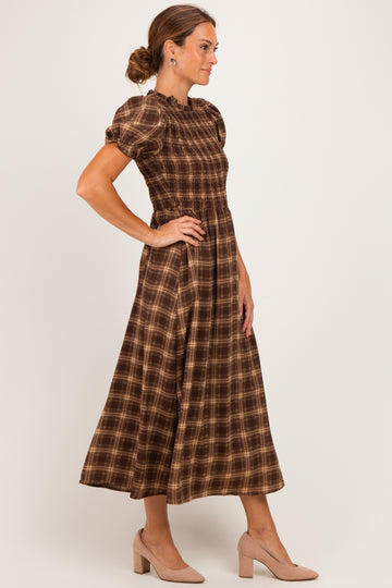 woman wearing a brown plaid midi dress with puff sleeves and a smocked bodice, posing sideways