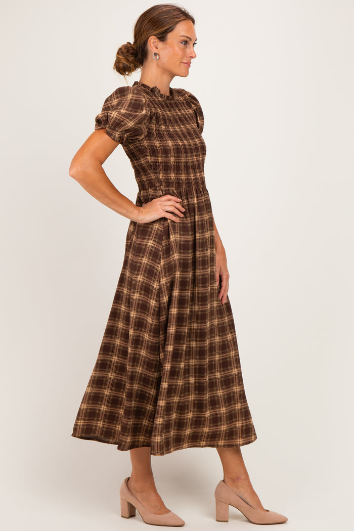 woman wearing a brown plaid midi dress with puff sleeves and a smocked bodice, posing sideways