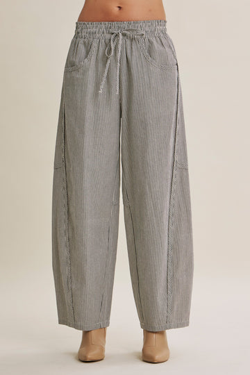 woman wearing black and white striped wide-leg pants with an elastic waistband and side pockets