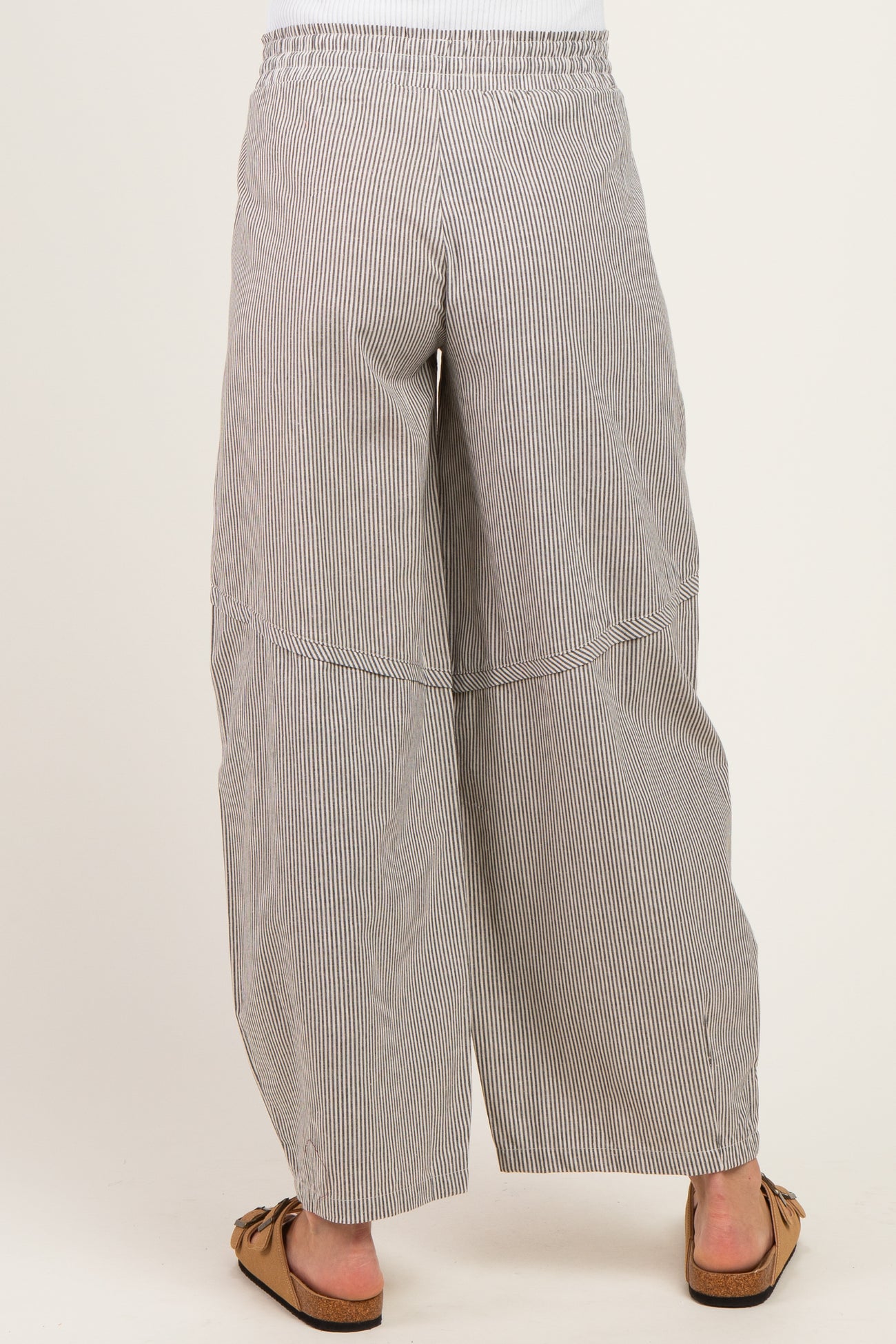 woman wearing black and white striped wide-leg maternity pants, showcasing the back view with an elastic waistband