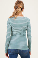 woman wearing a teal and white striped long sleeve maternity top, viewed from the back