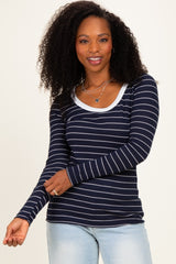 woman wearing a navy blue striped long sleeve top with a scoop neckline and gray trim, smiling at the camera